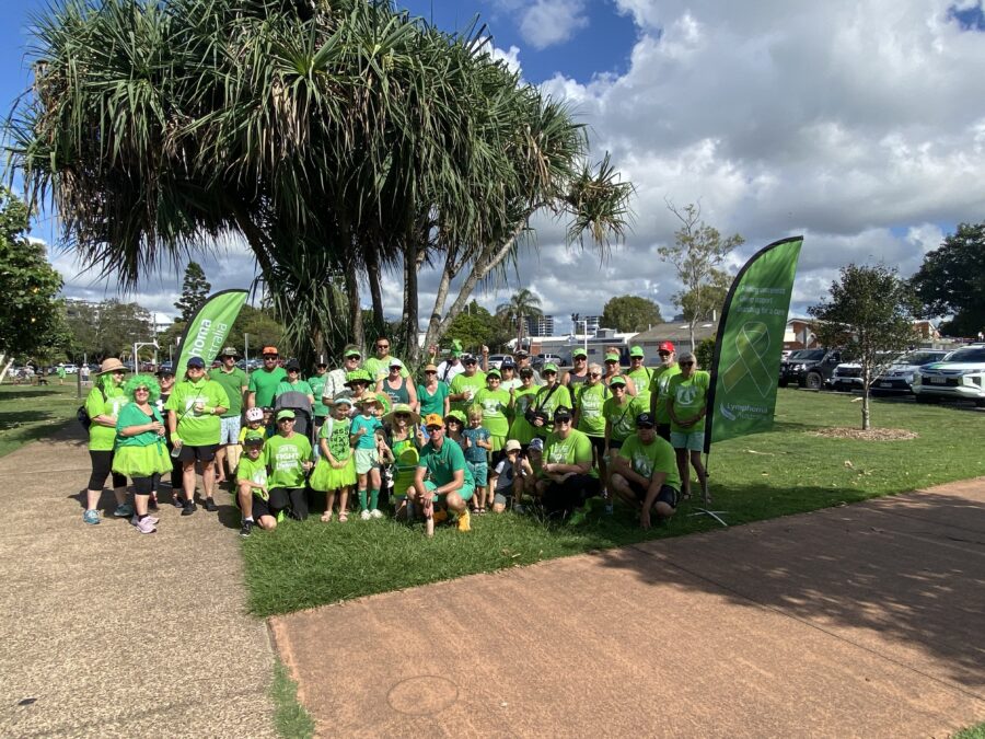 An image of a group of people wearing lime green at a park with Lymphoma Australia Banners celebrating Legs out for Lymphoma.