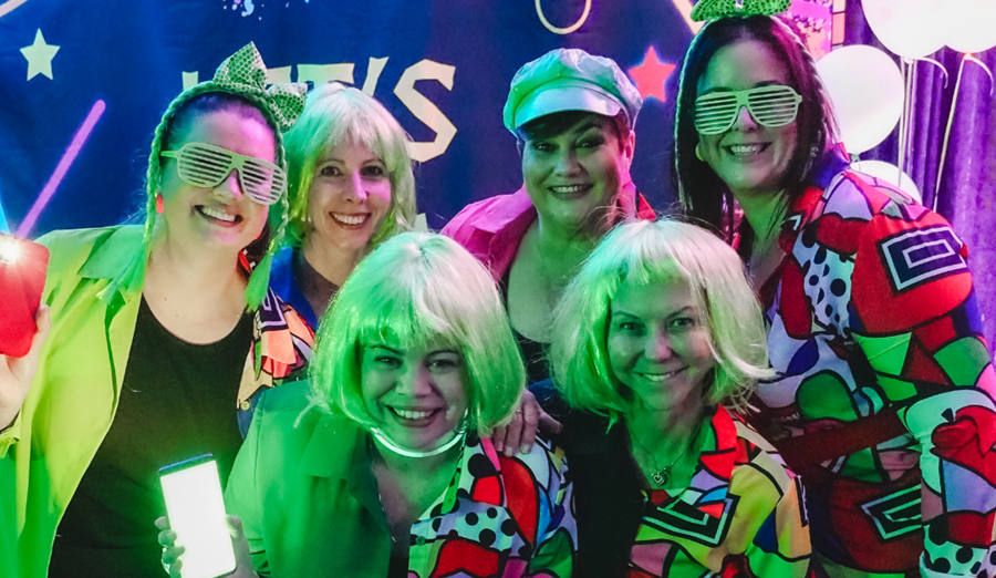 Lymphoma Australia staff putting Lymphoma in the LIMELIGHT in retro lime wigs, glasses and matching colourful jackets